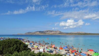 Badegäste am Strand auf der Mittelmeerinsel Sardinien.