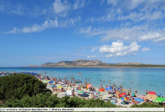 Badegäste am Strand auf der Mittelmeerinsel Sardinien.