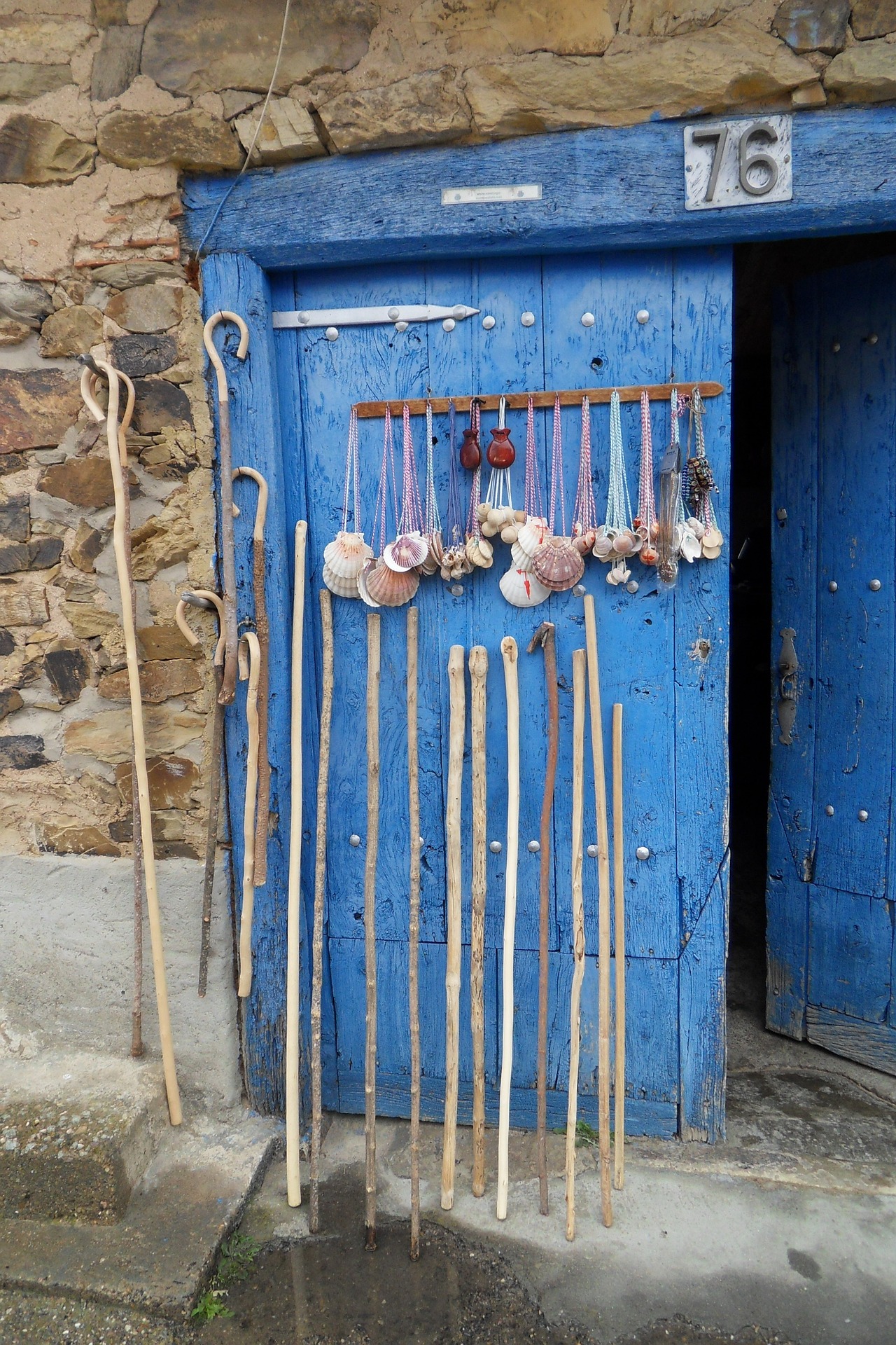 Pilgerstäbe angelehnt an eine blaue Tür