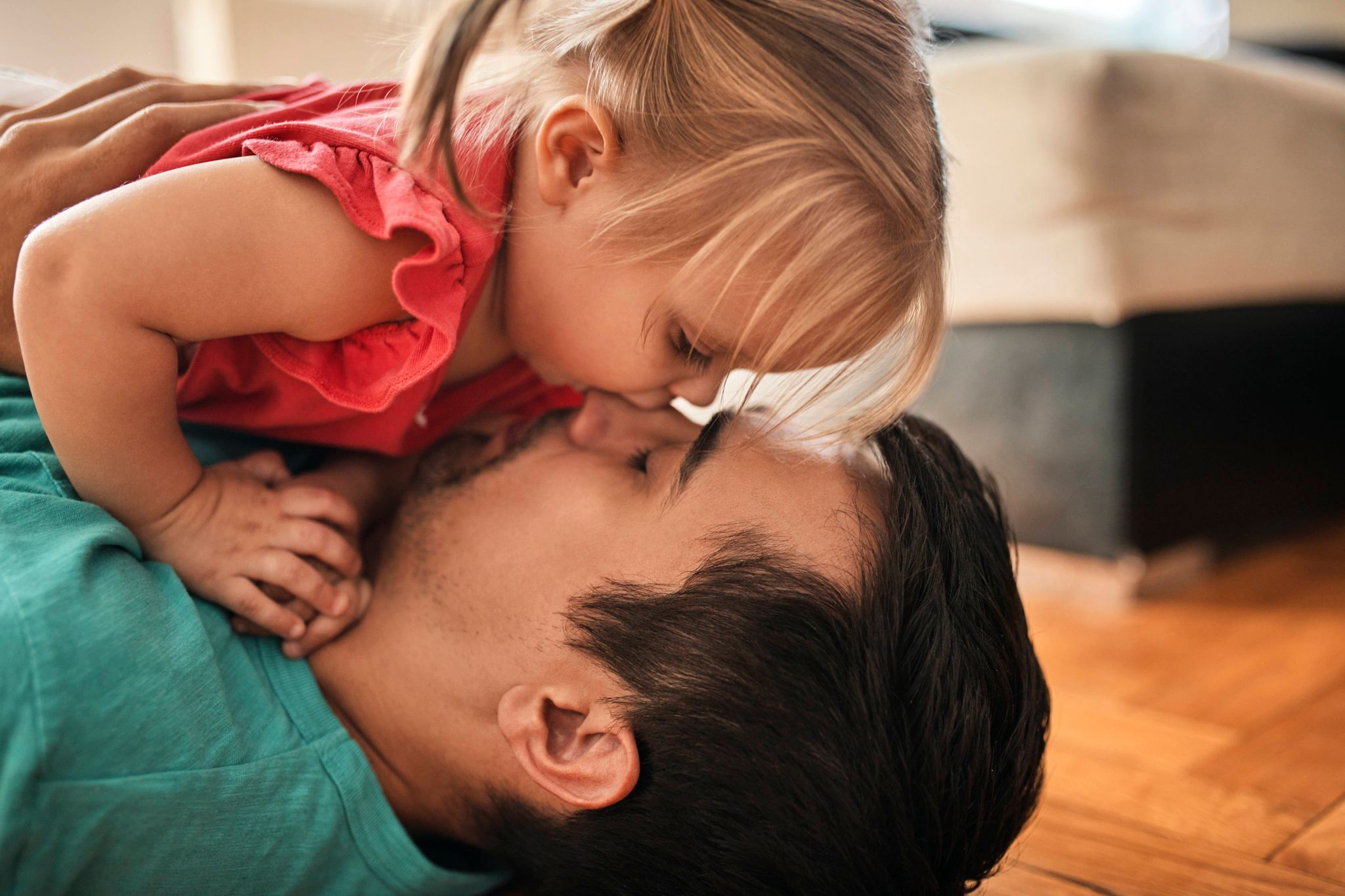 Vater und Tochter kuscheln zunächst ganz friedlich. Bis das Töchterchen Papa unvermittelt in die Nase beißt - Aua!