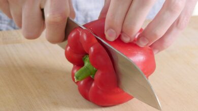 1. Schritt: Wasche die Paprika zuerst und lege sie dann seitlich auf dein Schneidebrett. Schneide dann den oberen Teil kurz vor dem Strunk ab.