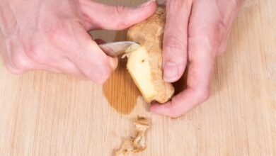 Der Ingwer wird mit der einen Hand festgehalten. In die andere Hand nimmt man die Mulde eines Teelöffels, so dass man mit der Innenseite gut kratzen kann.