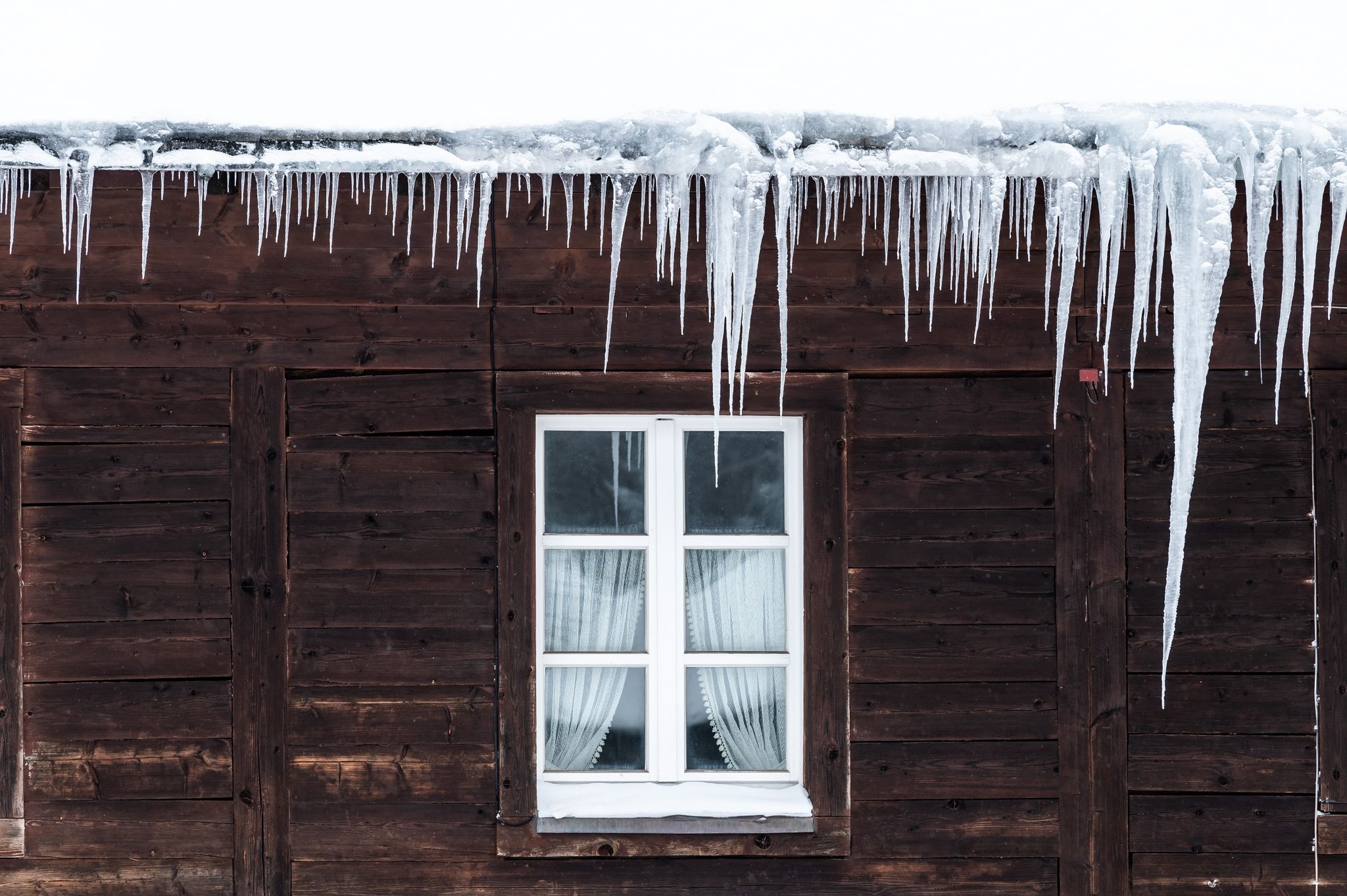 Eiszapfen sind ein Anzeichen für verstopfte Dachrinnen. Wenn Tauwetter einsetzt, kann das Wasser an den Rinnenkanten herunterlaufen und den Putz durchfeuchten.