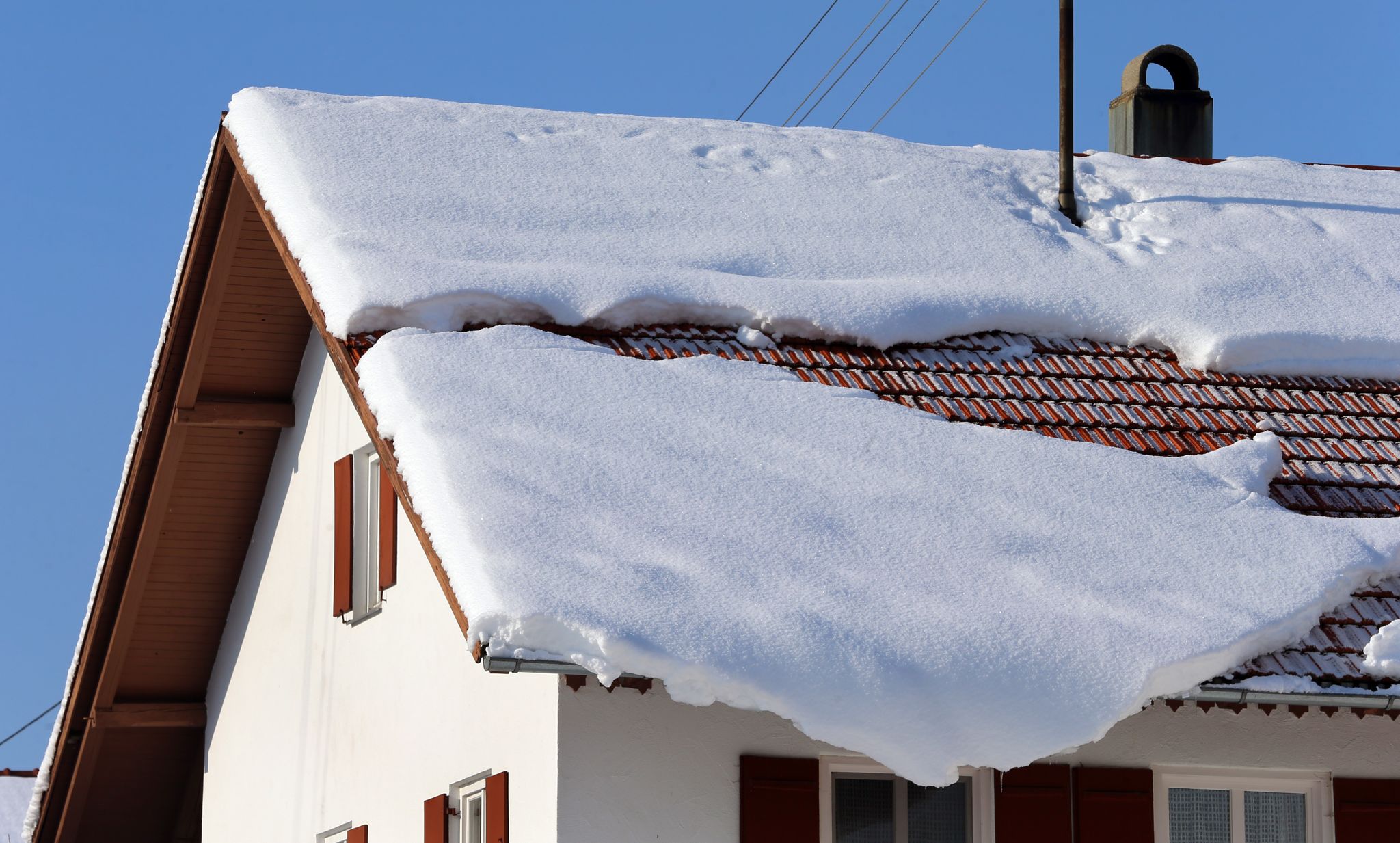 Bei starkem Schneefall sollten Hausbesitzer ihr Dach im Auge behalten.