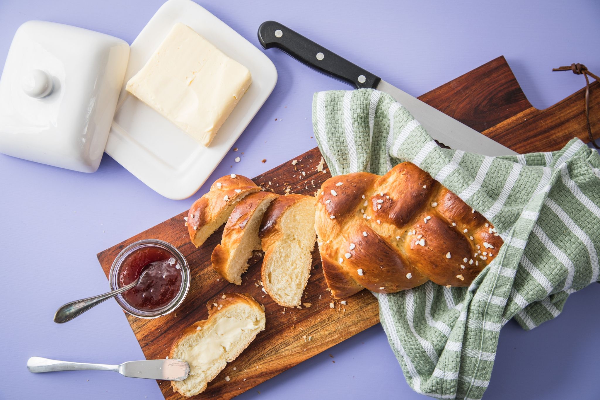 Frisch aus dem Ofen: Der mit Hagelzucker bestreute Hefezopf wird aufgeschnitten und am besten mit Butter oder Erdbeer-Marmelade bestrichen.