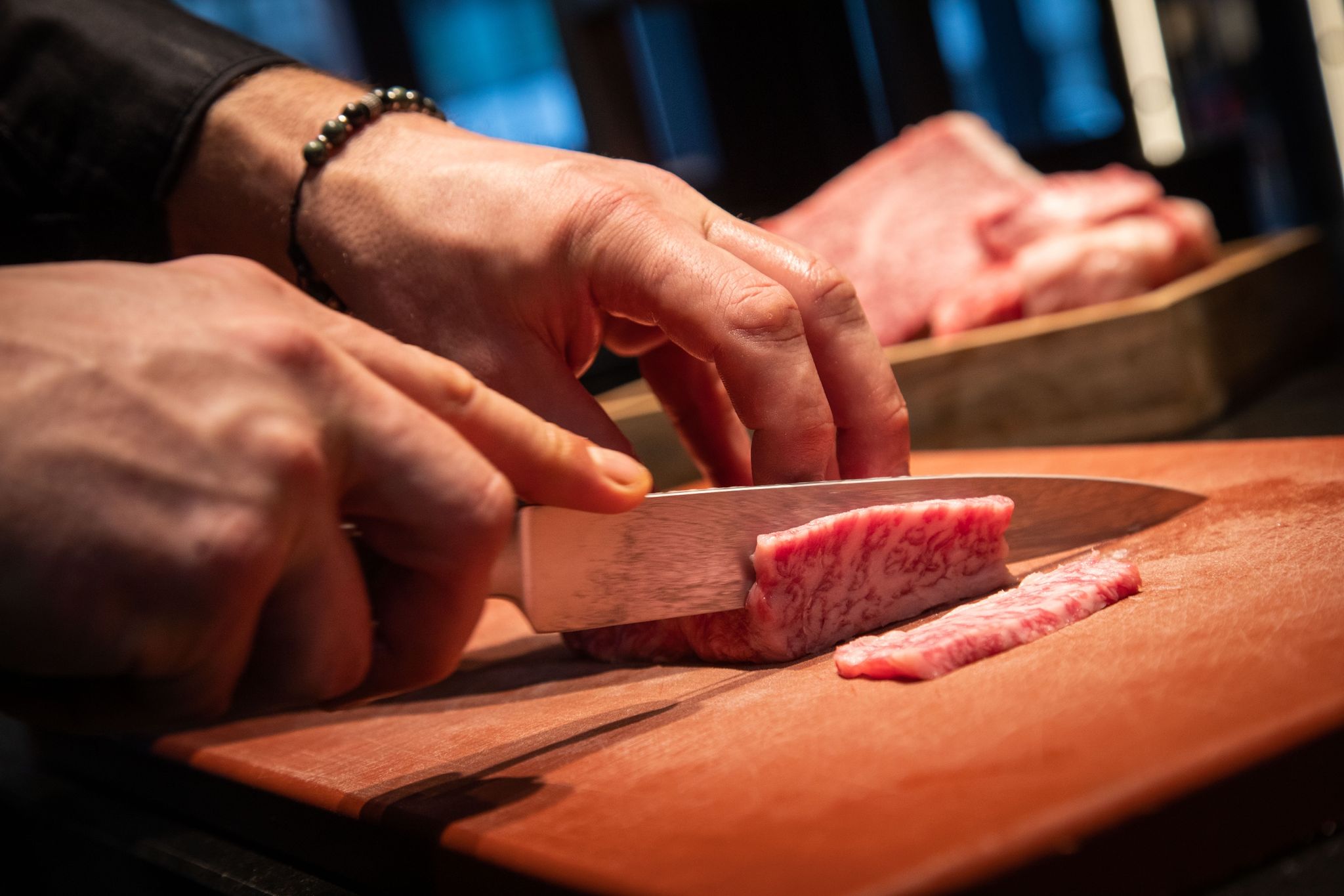 Aus einer dickeren, etwa 2,5-Zentimeter dicken Scheibe Wagyu Beef, werden für das Hot Pot Gericht 0,5-Zentimeter dünne Streifen geschnitten.