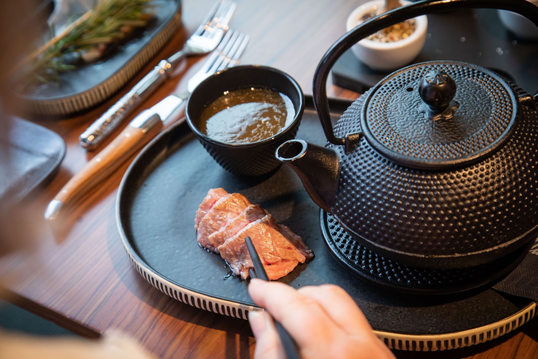 Jeder angeröstete Wagyu-Streifen wird bei dem Rezept für Hot Wagyu Tea im Shabu Shabu Style einzeln in heißer Rinderbrühe geschwenkt.