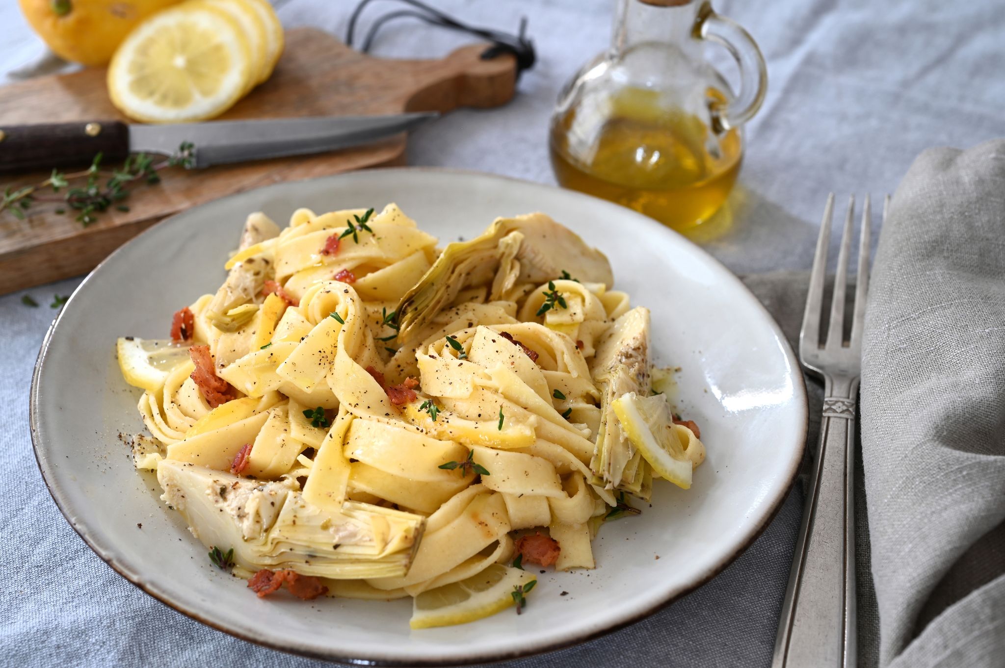 Neben der cremigen Artischockensoße machen auch gegrillte Artischockenherzen, knuspriger Bauchspeck und süßliche Zitrusnoten aus einfachen Bandnudeln einen herzhaften Pastaschmaus.