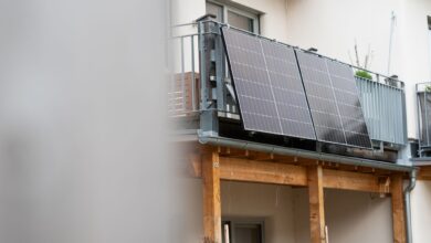 Eine Balkonsolaranlage hängt an einem Wohnhaus. Mit der richtigen Ausrichtung kann man kräftig Stromkosten einsparen.