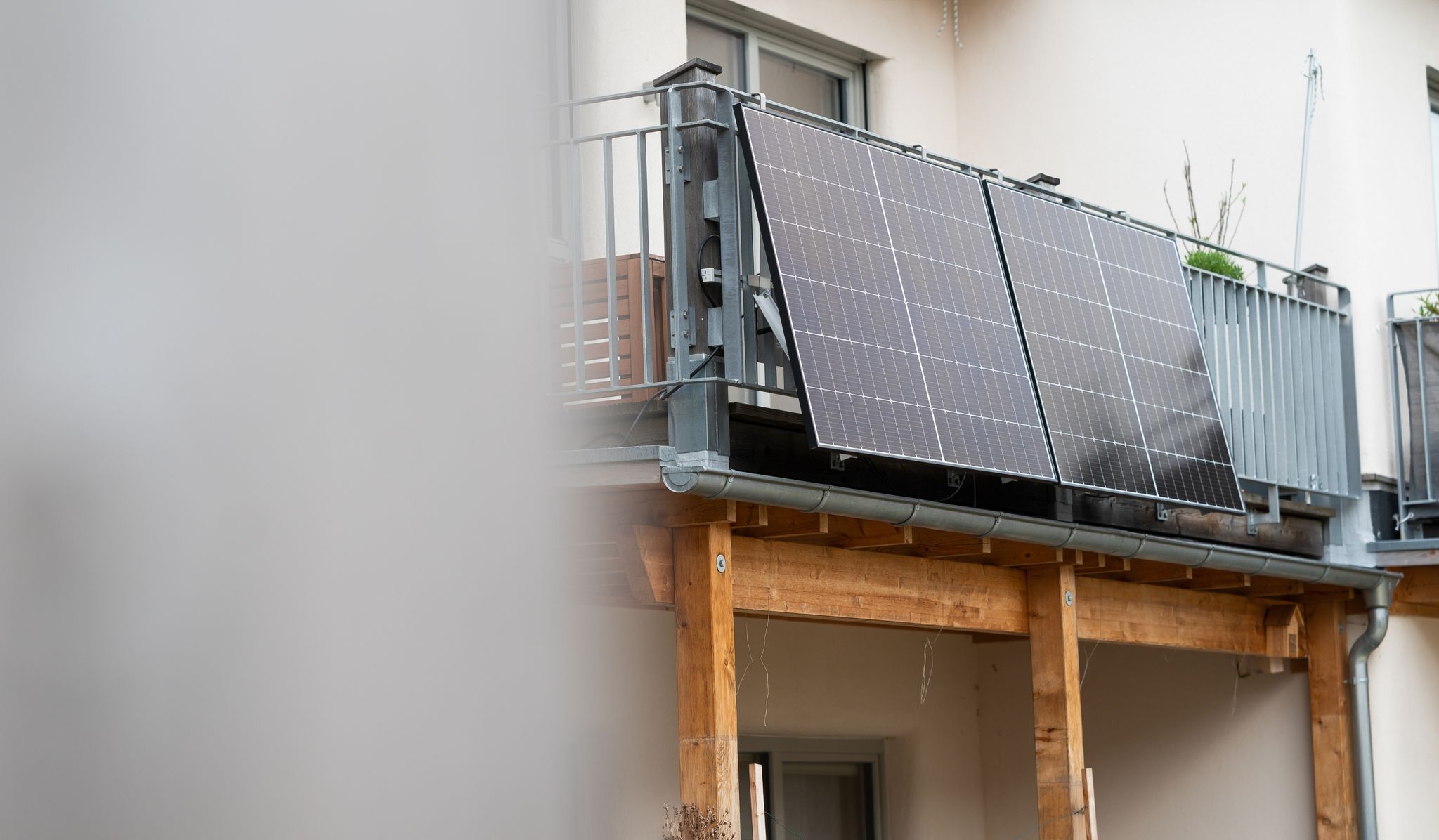 Eine Balkonsolaranlage hängt an einem Wohnhaus. Mit der richtigen Ausrichtung kann man kräftig Stromkosten einsparen.
