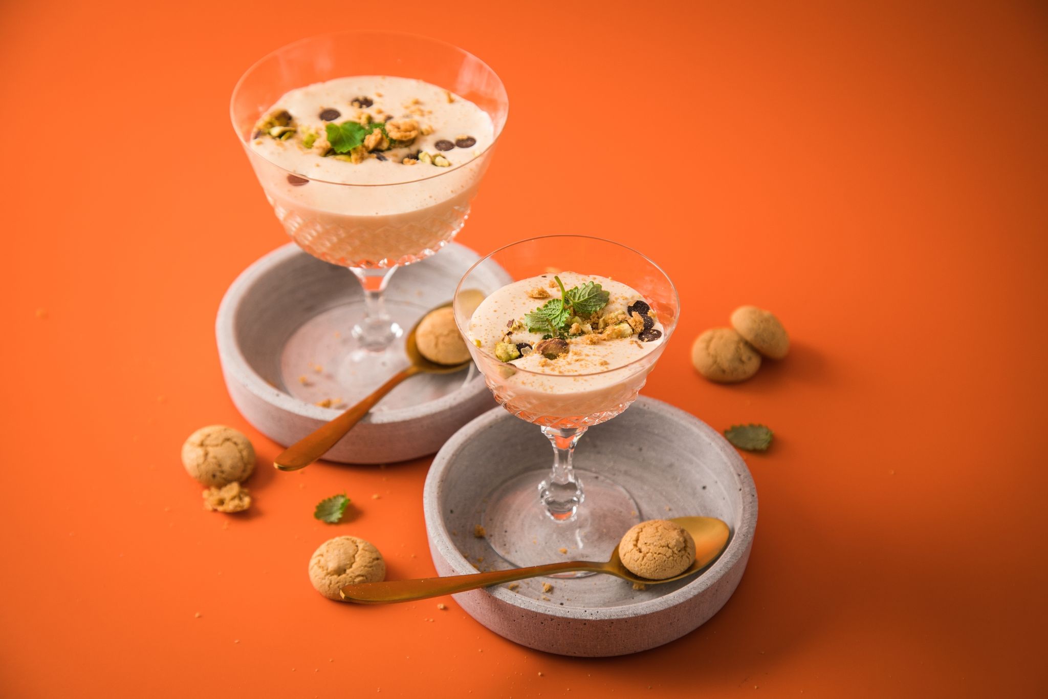 Ganz klassisch wird die Zabaione in Gläser gefüllt und beispielsweise mit Amarettini, Melisse, Schoko-Drops und Pistazie dekoriert.