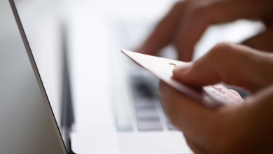 Mann Hält Kreditkarte Neben Einem Laptop In Der Hand