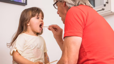Arzt Untersucht Den Rachen Eines Kleinen Mädchens