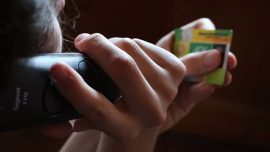 Ein Mann Hält Beim Telefonieren Eine Gesundheitskarte