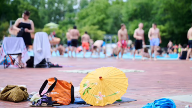 Handtücher Und Rücksäcke Liegen Am Beckenrand Eines Freibads