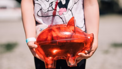 Ein Kind Trägt Ein Rotes Sparschwein