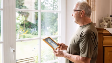 Mann Steht Mit Einem Hochzeitsfoto Am Fenster