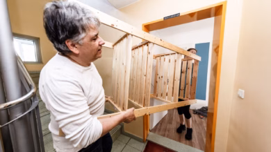 Mann trägt ein regal durch ein treppenhaus