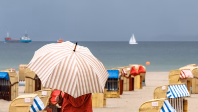 Eine Frau Mit Schirm Am Strand