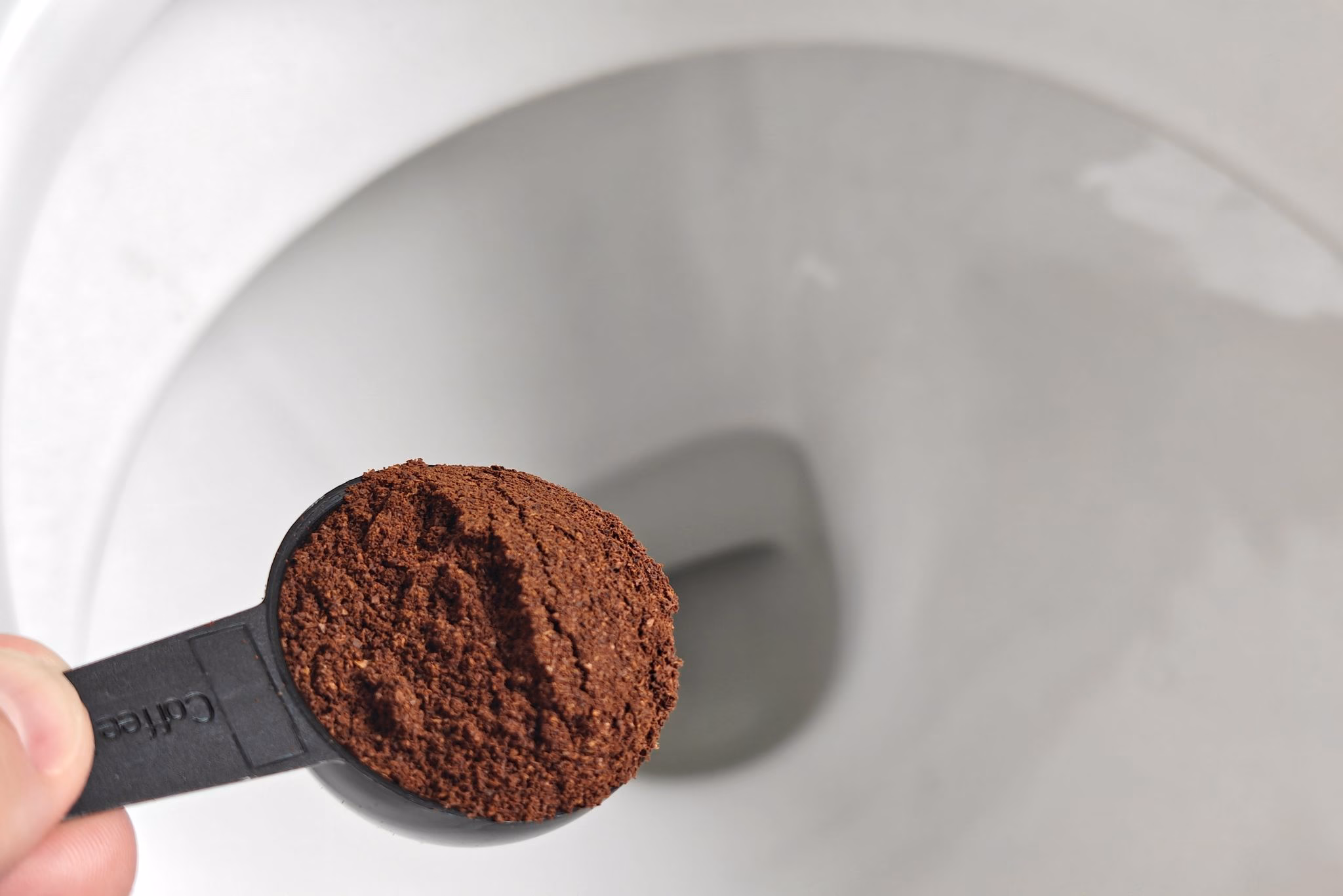 Löffel kaffeesatz ist über einer toilette zu sehen