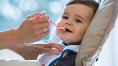 Ein baby wird mit brei gefüttert