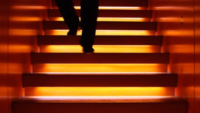 Mann geht eine angeleuchtete treppe hinab