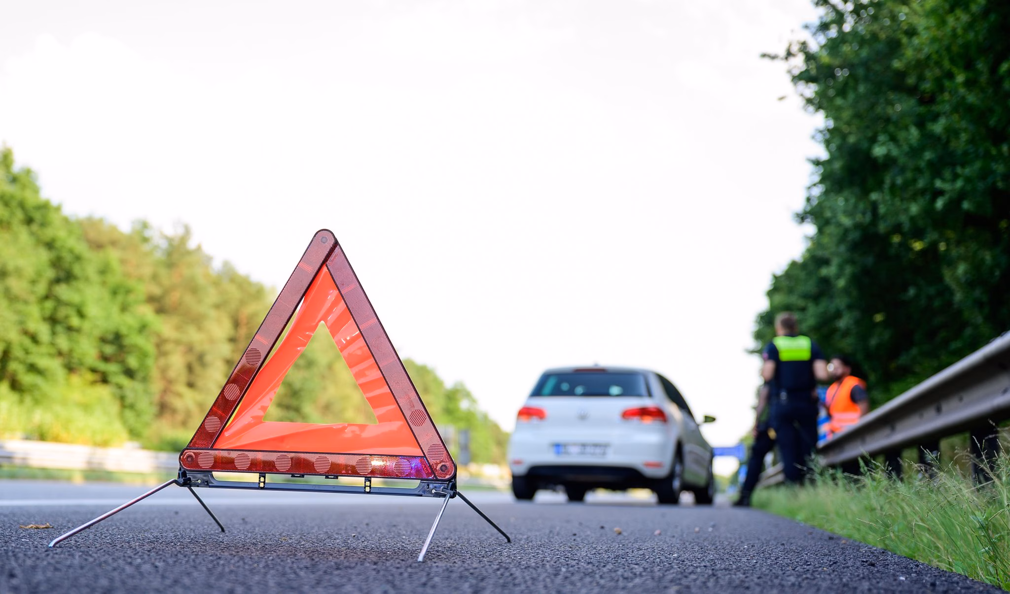 Mit warndreieck steht nach einer panne auf der autobahn