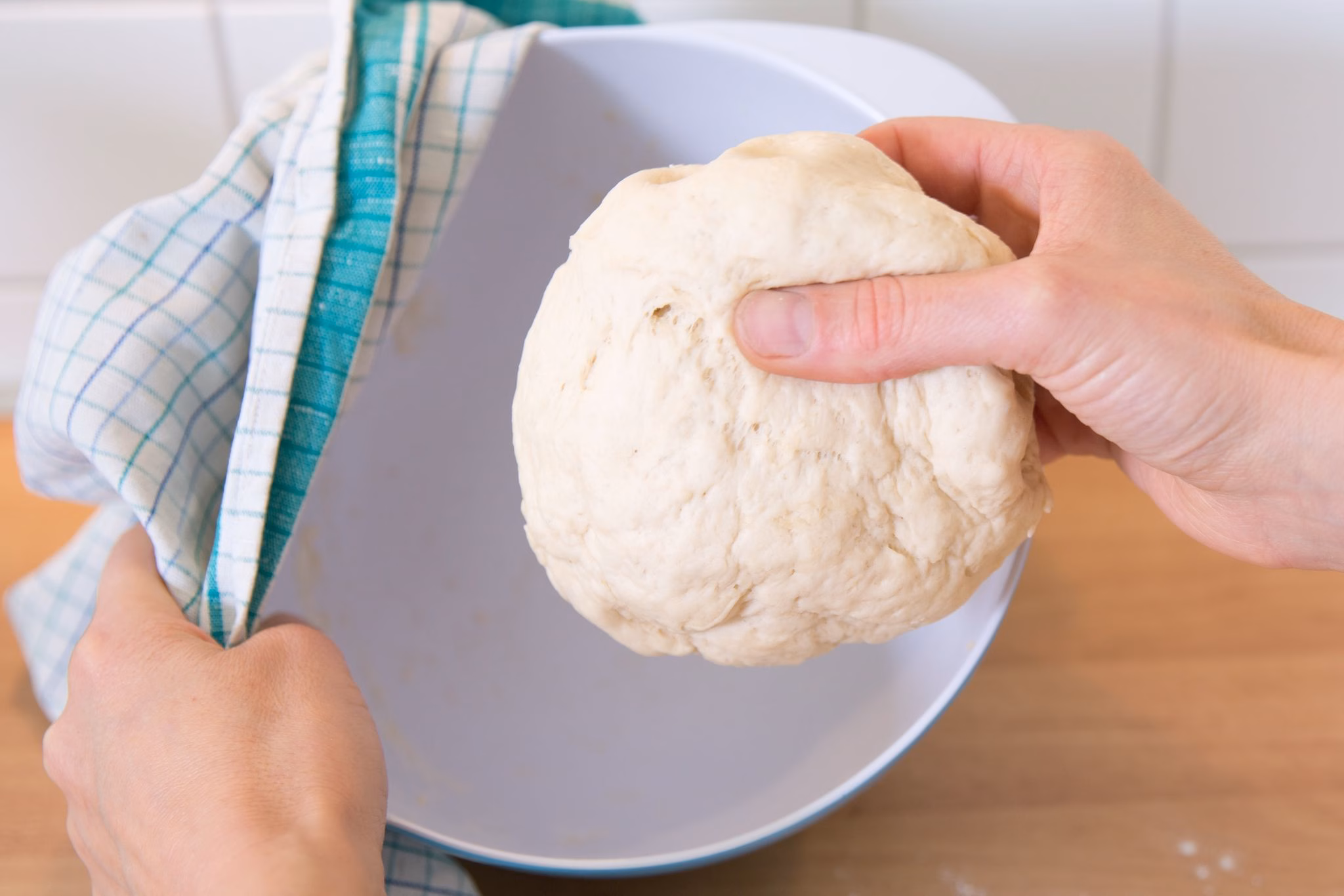 Frau hält einen hefeteig in der hand