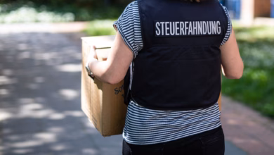 Mitarbeiterin der steuerfahndung trägt beschlagnahmte unterlagen