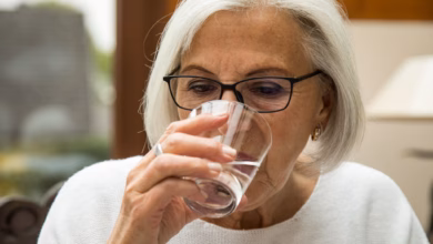 Eine seniorin trinkt ein glas wasser