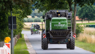 Landwirt fährt mit seinem mähdrescher auf einer landstraße