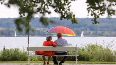 Renter sitzen mit einem schirm am see