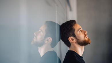 Ein junger mann lehnt nachdenklich an einer glaswand