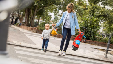Frau geht mit ihrem kind über eine straße