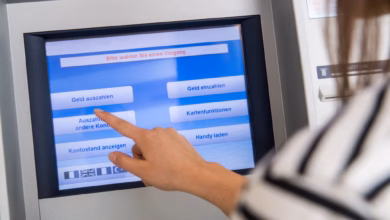 Frau hebt geld an einem automaten ab