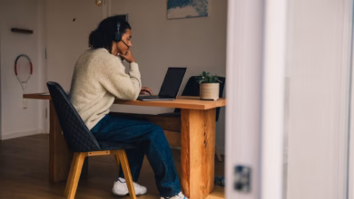 Mann sitzt bei einer videokonferenz am laptop