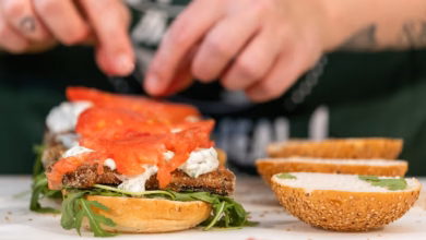 Eine köchin belegt einen burger mit veganem fischersatz