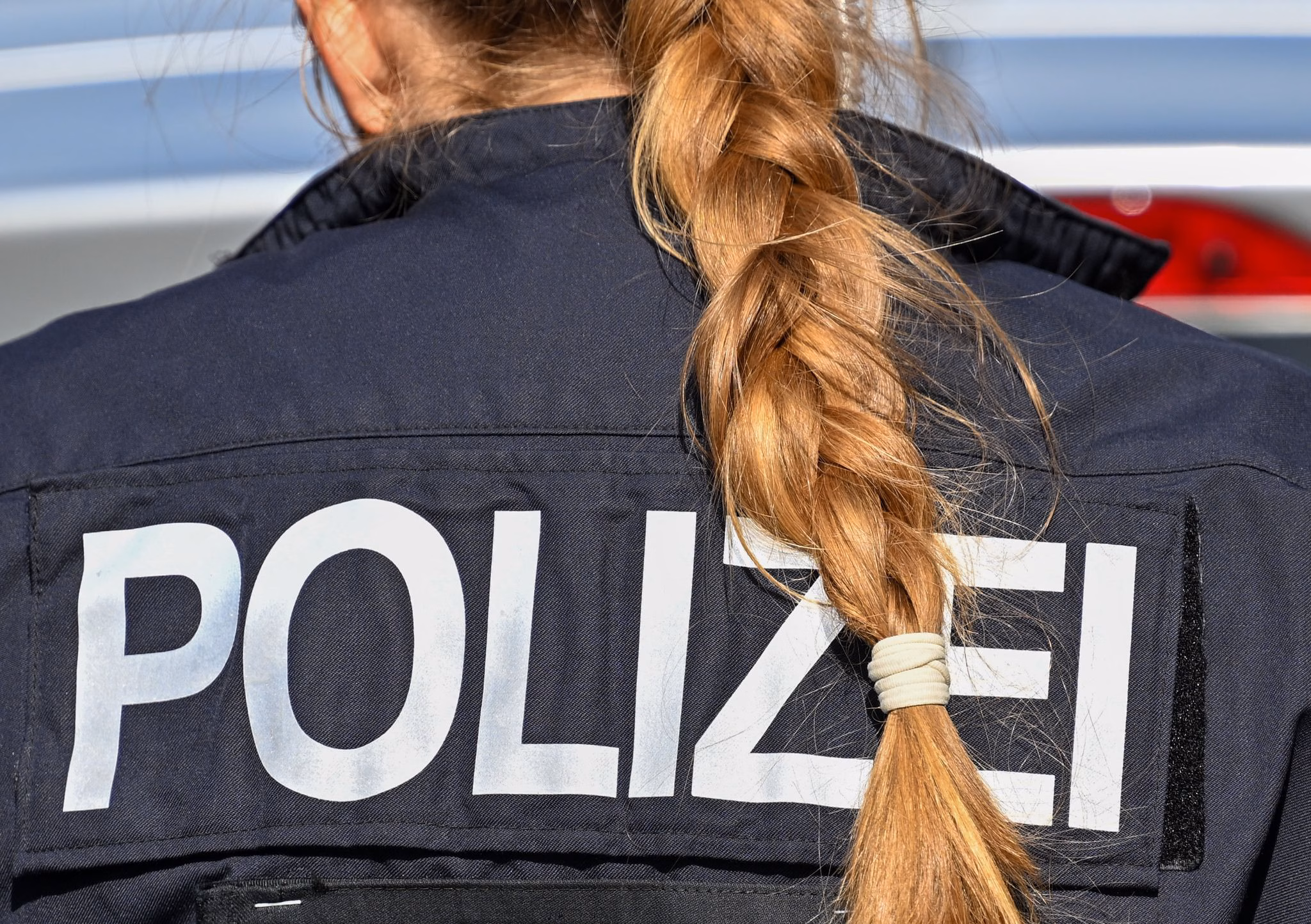Der zopf einer polizistin hängt über ihre uniform.