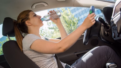 Frau trinkt während der autofahrt aus einer wasserflasche