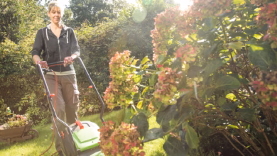 Frau mäht den rasen im garten