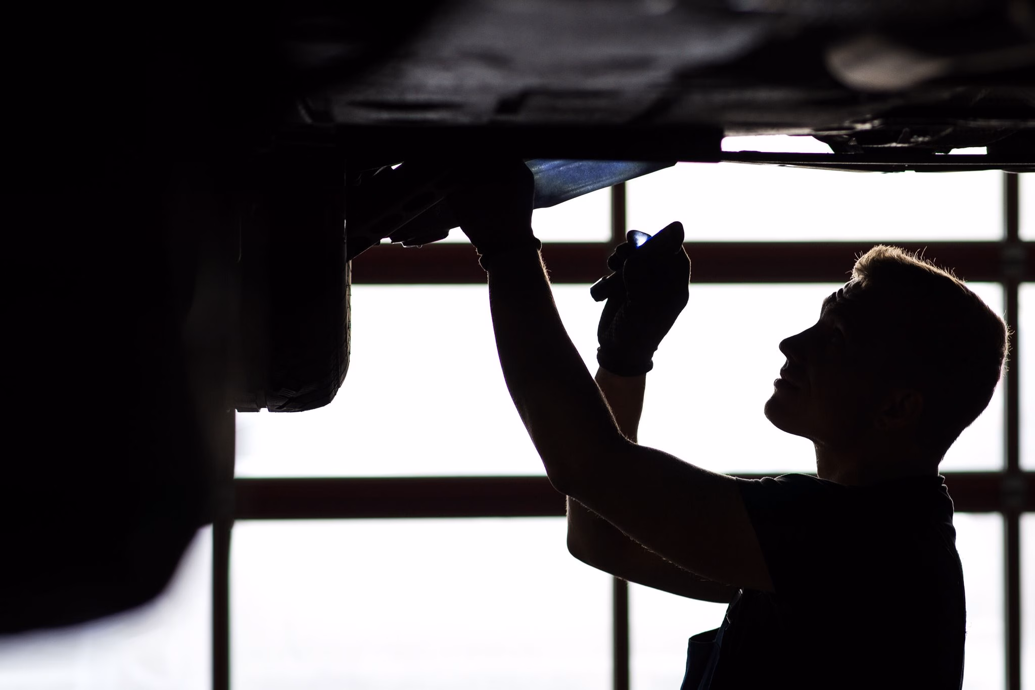 Ein mechaniker begutachtet ein kfz in einer autowerkstatt