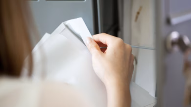 Eine frau öffnet am briefkasten einen brief