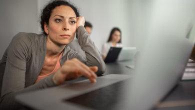 Frau sitzt frustriert vor einem laptop