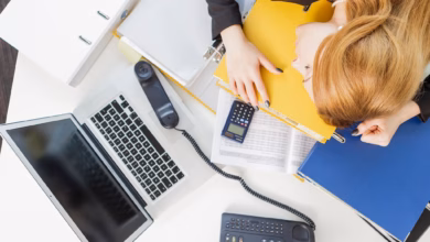 Eine frau legt den kopf auf einem schreibtisch nieder