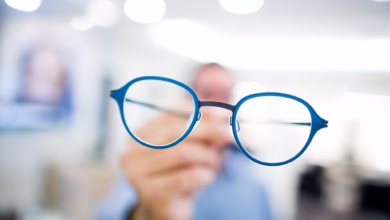 Optiker hält eine brille in der hand