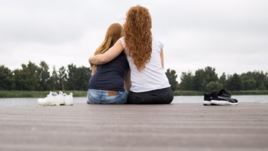 Zwei frauen sitzen auf einem steg am see