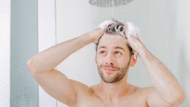 Mann wäscht sich unter der dusche die haare