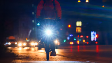 Radfahrer fährt mit licht am morgen eine straße entlang
