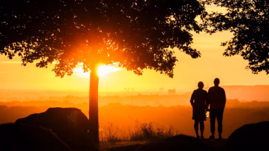 Ein paar steht bei sonnenaufgang auf einem berg