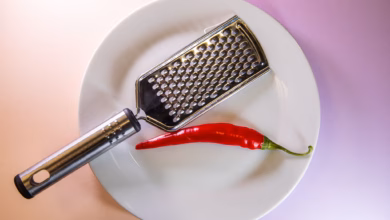 Chilischote liegt neben einer küchenreibe